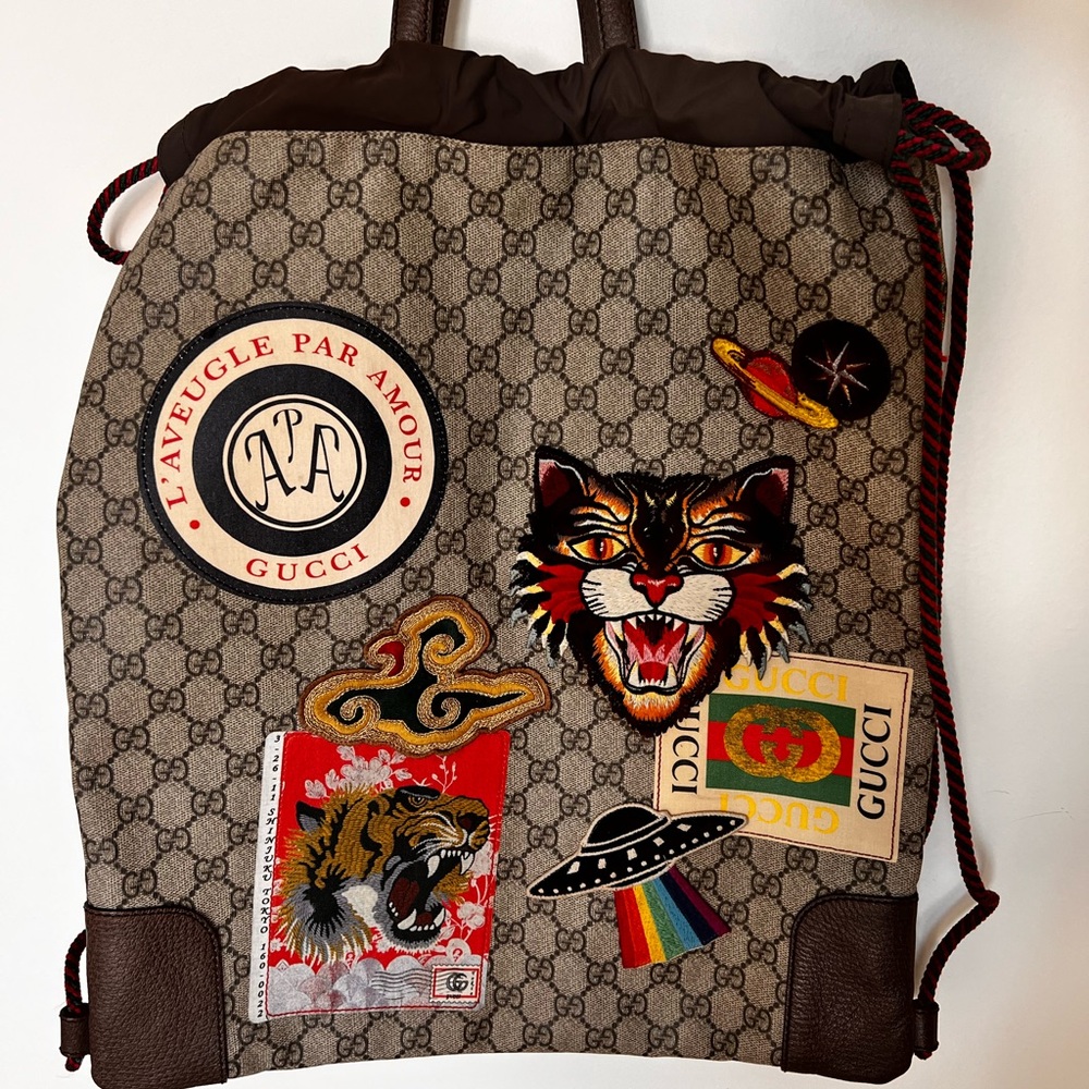 Gucci GG Supreme Courier backpack with patches.